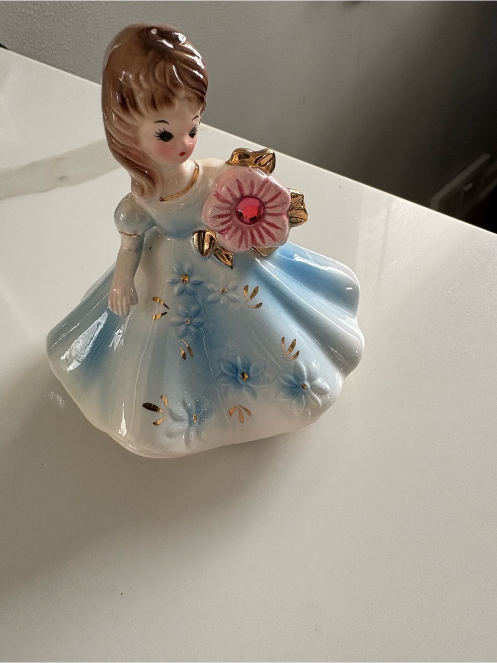 Blue and White Porcelain Girl Figurine with Pink Flower Accent